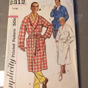 May include: A vintage Simplicity pattern envelope with illustrations of men's robes. The main image shows a man in a red and white plaid robe. The envelope is labelled "2312 Large" and "Printed Pattern 50c".