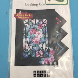 Peut inclure: Un paquet pour un projet artisanal "Looking Glass". Le motif présente un vitrail floral avec des roses roses et blanches, des hortensias bleus et une bordure noire. Le paquet comprend le texte "Optional Border Treatments" et "patchworks studio".