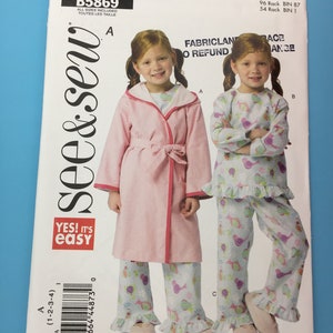 May include: A sewing pattern for two children's outfits. The pattern includes a pink robe with a sash and a pair of floral print pajamas with ruffled hems. The pattern is labeled "See & Sew" and "Yes! It's Easy".