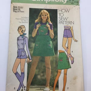 Könnte beinhalten: Vintage-Schnittmuster für einen Minirock, Shorts und einen Overall. Das Schnittmuster ist Simplicity 9828 und ist für die Größen 11/12, Brustumfang 32. Das Schnittmuster ist für junge Juniorinnen, Teenager und Damen. Das Schnittmuster enthält eine Gewebeschnittmusterkarte zum Oberfädeln.
