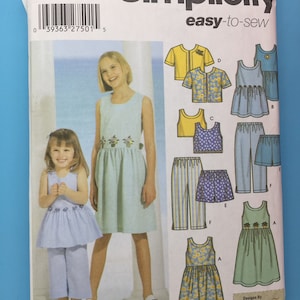 Può includere: Modello di cucito Simplicity numero 5168 per abiti e pantaloni da ragazza. Il modello include un abito senza maniche con stampa floreale, un abito senza maniche con stampa a quadri, un abito senza maniche con stampa floreale gialla, un top senza maniche giallo, un top senza maniche blu, un pantalone a righe, un pantaloncino blu a pois e un pantaloncino verde a quadri. Il modello è per le taglie K5, 7, 8, 10, 12 e 14.