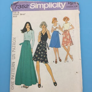 May include: Simplicity sewing pattern number 7352 for a wrap skirt. The pattern is for size 12 with a 26 1/2 inch waist. The pattern shows three different styles of wrap skirts, one in green, one in black and white floral print, and one in blue.