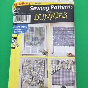 Op de afbeelding: Een naaipatroon voor raambekleding, getiteld "Naaipatronen voor Dummies." Het patroon bevat instructies voor het maken van drie verschillende stijlen raambekleding, met een bloemenprint, een geruite print en een effen kleur. Het patroon is van Simplicity, en het patroonnummer is 986.