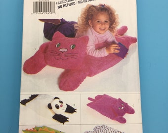 Puede incluir: Un patrón de costura para hacer cuatro almohadas de animales de peluche diferentes. Las almohadas son un gato rosa, un panda blanco y negro, un gato morado y un animal manchado blanco y negro. El patrón es de Butterick y es el número 4224.