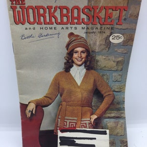 May include: The Workbasket and Home Arts Magazine cover from January 1974 features a woman wearing a brown knitted sweater with a geometric pattern and a brown and white knit hat. The magazine cover costs 25 pence.