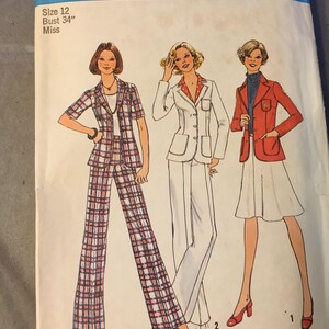 May include: Vintage Simplicity sewing pattern 6876. The pattern features illustrations of three different outfits: a plaid pantsuit, a white pantsuit, and a red jacket with a white skirt. The pattern size is 12, with a 34-inch bust.