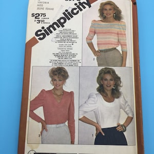 Puede incluir: Patrón de costura Simplicity número 5378 para una blusa de mujer con mangas abullonadas. El patrón incluye tres vistas diferentes: una blusa rosa con cuello en V, una blusa blanca con cuello redondo y una blusa a rayas con cuello redondo. El patrón está diseñado para tejidos de punto elásticos únicamente.