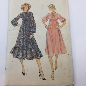 May include: Vogue Patterns sewing pattern for a dress with two different styles. The pattern is for size 8 and features a floral print dress and a solid pink dress. The pattern costs £3.00 in Canada.