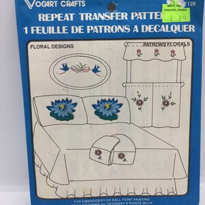 May include: A blue and white package with the text "Repeat Transfer Pattern" and "1 Feuille de Patrons a Decalquer" on the front. The package features a floral design with blue birds, flowers, and a bed with pillows and a blanket.