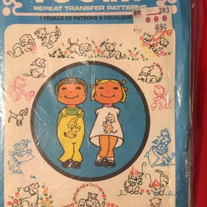 May include: A vintage Vogart repeat transfer patterns package. The package is blue with illustrations of puppies, kittens, and children. The text "VOGART" and "REPEAT TRANSFER PATTERNS" are visible. A price tag is attached.