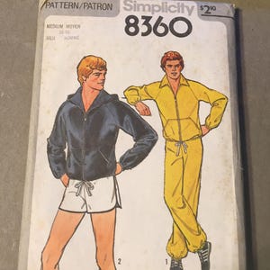 Könnte beinhalten: Vintage Simplicity Schnittmuster 8360 mit Illustrationen eines Mannes in einer marineblauen Kapuzenjacke und weißen Shorts sowie einem gelben Trainingsanzug. Der Schnitt enthält den Text "PATTERN/PATRON" und "MEN HOMME".