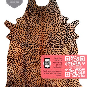 May include: A brown and black cowhide rug with a leopard print pattern. The rug is folded in half and has a QR code on the bottom right corner with the text "Scan this QR code to save big on your next order. We'll also keep you up to date with the latest trends. SOUTHERNHIDES"