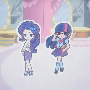May include: Two cartoon character stickers, one with purple hair and a blue dress, the other with pink and blue hair wearing a blue and white school uniform and holding a book.
