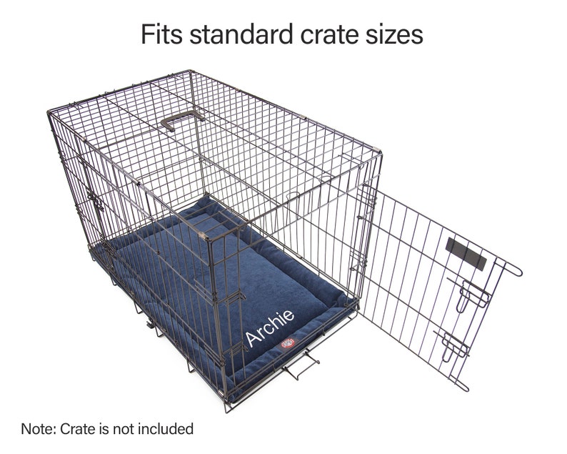 May include: A blue dog bed with the name "Archie" embroidered on it. The bed is inside a metal dog crate with the door open. The crate is designed to fit standard crate sizes.