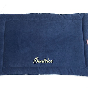 May include: A dark blue pet bed with a gold embroidered name "Beatrice".