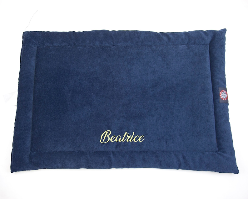 May include: A dark blue pet bed with a gold embroidered name "Beatrice".