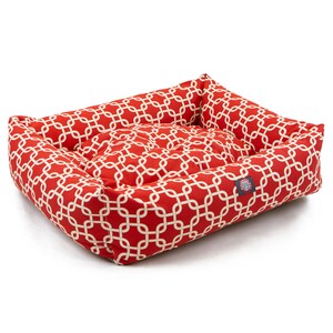 May include: Red and white patterned dog bed with a raised edge. The bed has a geometric pattern of white chains on a red background.