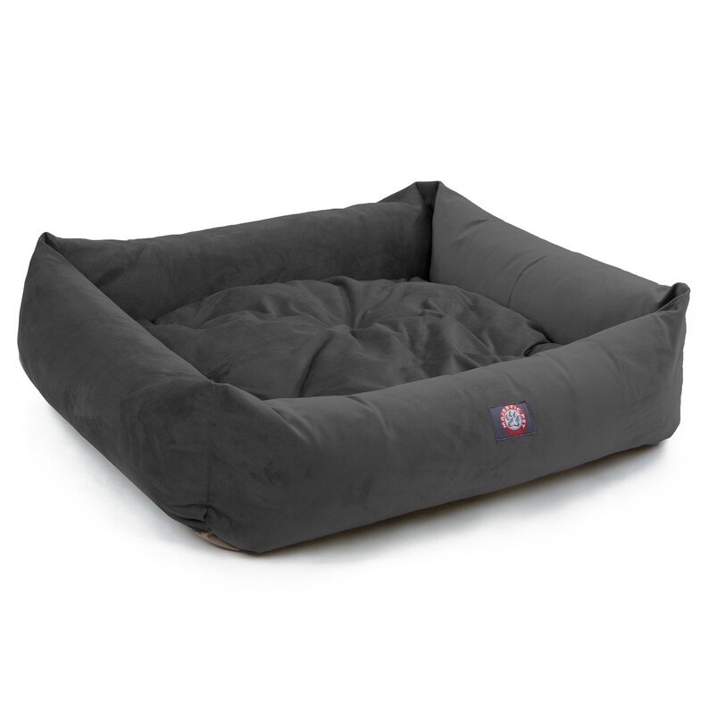 Puede incluir: Una cama para perros gris con un borde elevado y un interior suave y mullido. La cama tiene un peque&ntilde;o logotipo en el lateral.