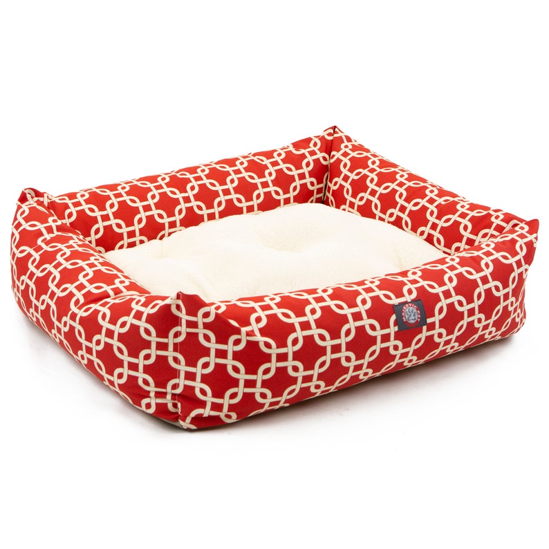 May include: Red and white patterned dog bed with a white, fluffy cushion. The bed has a raised edge and is made of a soft, durable fabric.