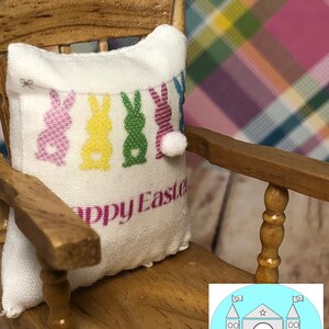 May include: A white pillow with a colorful Easter bunny design and the text "Happy Easter" on a wooden rocking chair.