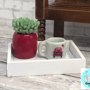 May include: A white tray with a red potted succulent and a white mug with a red car and the word "LOVE" on it.
