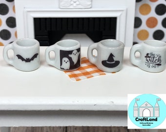 May include: Four miniature white ceramic mugs with black Halloween-themed designs. The mugs feature a bat, ghosts, a witch's hat, and the text "The witch is in".