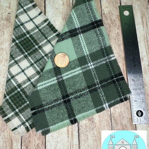 May include: Two triangular pieces of fabric with a plaid pattern. One is green and white, the other is green and black. The fabric has a frayed edge.