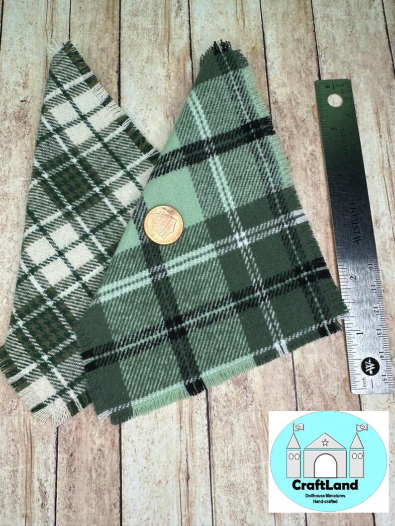 May include: Two triangular pieces of fabric with a plaid pattern. One is green and white, the other is green and black. The fabric has a frayed edge.