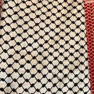 May include: A white and black patterned fabric with a red and white patterned fabric border.
