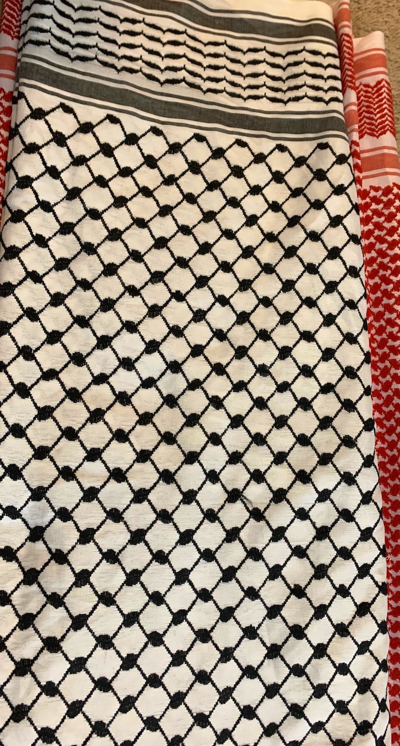 May include: A white and black patterned fabric with a red and white patterned fabric border.