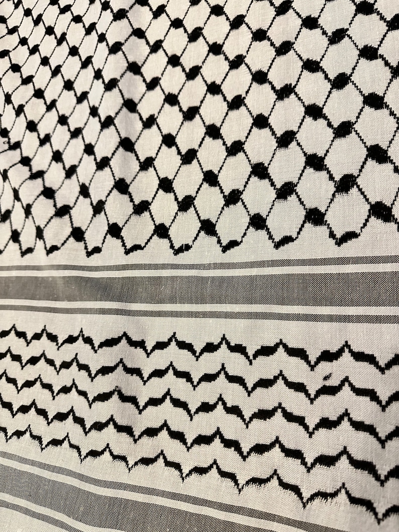 May include: A white and black patterned fabric with a geometric design. The fabric has a traditional Middle Eastern style.
