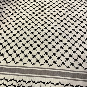 May include: White and black patterned fabric with a geometric design. The fabric has a black and white striped border.