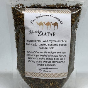 Może przedstawiać: Przezroczysty plastikowy woreczek wypełniony mieszanką suszonych zi&oacute;ł i przypraw o nazwie Zaatar. Etykieta zawiera napis "The Bedouin Company" i "Palestinian Zaatar". Składniki to dziki tymianek, hyzop, prażone nasiona sezamu, sumak i s&oacute;l. Etykieta informuje r&oacute;wnież, że Zaatar jest jednym z unikalnych i najlepszych przypraw na świecie, bogatych w intensywne smaki. M&oacute;wi się, że studenci na Bliskim Wschodzie jedzą go podczas egzamin&oacute;w, ponieważ twierdzą, że wzmacnia poznanie. Woreczek zawiera 2 uncje Zaatar.