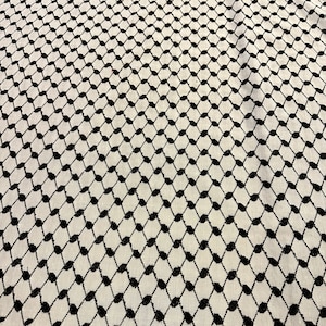 May include: A white and black patterned fabric with a repeating geometric design. The fabric has a subtle sheen and a soft texture.