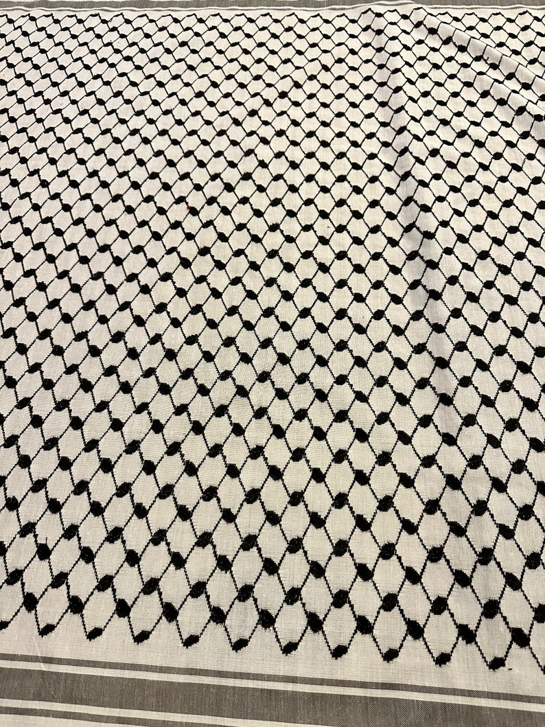 May include: A white and black patterned fabric with a repeating geometric design. The fabric has a subtle sheen and a soft texture.
