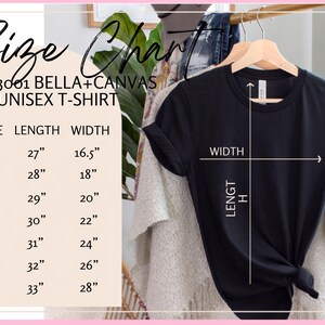 May include: A black Bella+Canvas 3001 unisex t-shirt hanging on a wooden hanger. A size chart is displayed on the left, listing lengths from 27 to 33 inches and widths from 16.5 to 28 inches for sizes XS through 3X, with white lines indicating measurements.