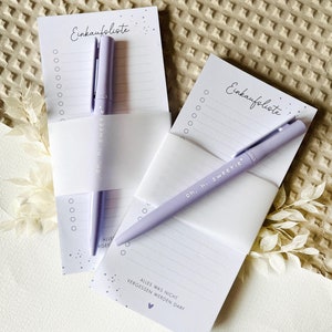 May include: Two purple shopping list pads with a purple pen on each. The pads have the text "Einkaufsliste" and "Alles was nicht vergessen werden darf" printed on them. The pens have the text "oh, hi sweetie" printed on them.