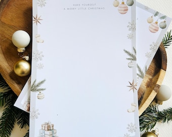 May include: Stationery set with a light gray border, featuring Christmas ornaments, snowflakes, and the text "Have Yourself A Merry Little Christmas." The set includes a wooden tray, ornaments, and pine branches.