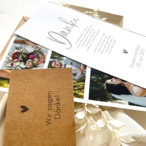 May include: A thank you card with a simple design and a handwritten message in German. The card is decorated with a small heart and a photo of a bouquet of flowers. The text on the card reads "Danke" and "Wir sagen Danke!"