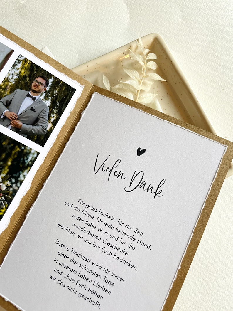 May include: A thank you card with a handwritten message in black ink on a white background. The card has a brown border and a small black heart in the top right corner. The text reads "Vielen Dank" and includes a message of gratitude for the recipient's support.