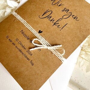 May include: A brown card with the text "Wir sagen Danke!" and "Nicole & Kevin" with a heart symbol. The card also includes the date "10. Oktober 2024" and the text "Es war ein wundersch&ouml;ner Tag."