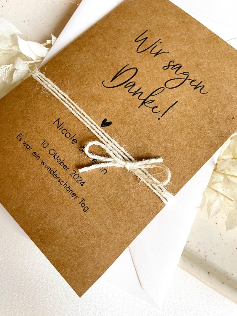 May include: A brown card with the text "Wir sagen Danke!" and "Nicole & Kevin" with a heart symbol. The card also includes the date "10. Oktober 2024" and the text "Es war ein wundersch&ouml;ner Tag."
