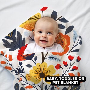 May include: A white baby blanket with a floral pattern in shades of yellow, orange, red, and blue. The blanket is made of soft, plush fabric and is perfect for cuddling up with a baby or toddler. The text "BABY, TODDLER OR PET BLANKET" is printed on the blanket.