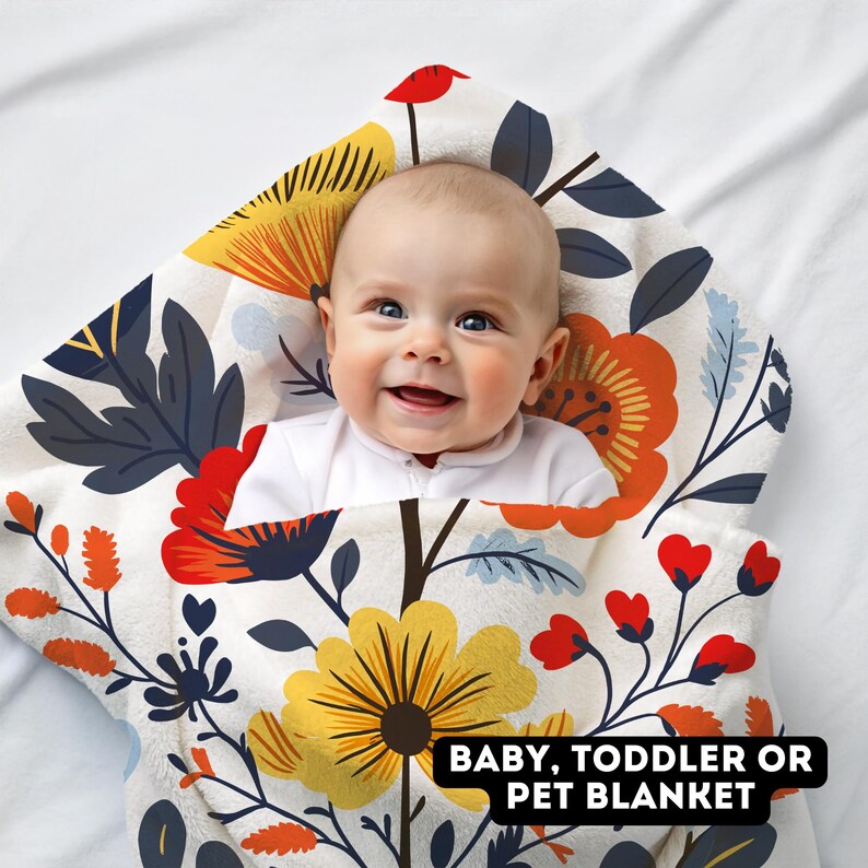 May include: A white baby blanket with a floral pattern in shades of yellow, orange, red, and blue. The blanket is made of soft, plush fabric and is perfect for cuddling up with a baby or toddler. The text "BABY, TODDLER OR PET BLANKET" is printed on the blanket.