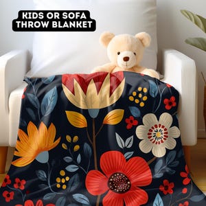 May include: A floral throw blanket with a dark blue background and colorful flowers in shades of red, yellow, and white. The text "Kids or Sofa Throw Blanket" is printed on a black label in the top left corner of the image.