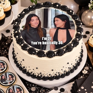 Peut inclure: Un gâteau rond au glaçage blanc, décoré de rosettes noires pochées et de petites perles blanches et noires. Le dessus présente une image comestible de deux personnes avec le texte, I'm 27. You're basically 30. La base est ornée de perles éparpillées.