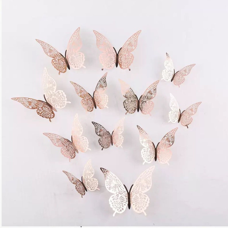 May include: A set of 12 decorative 3D butterfly wall decals in various shades of pink and white. The butterflies have a delicate, lacy design and are perfect for adding a touch of whimsy to any room.
