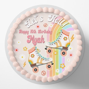 Könnte beinhalten: Ein runder rosa und weißer Kuchen mit einem bunten Design mit Rollschuhen, Regenbögen und Blumen. Der Text "Let's Roll!" und "Happy 10th Birthday Mya" ist auf den Kuchen gedruckt.