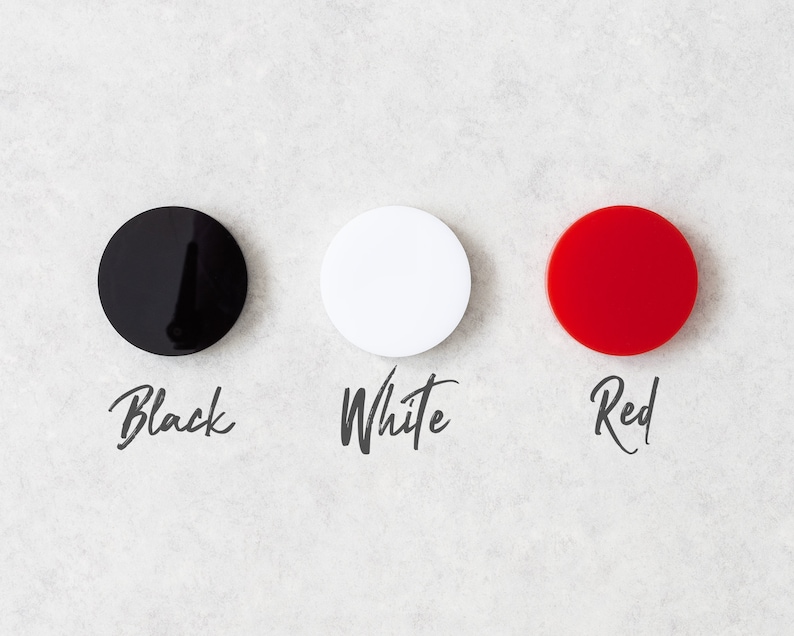 May include: Three round discs, one black, one white, and one red, with the words "Black", "White", and "Red" written below each disc.