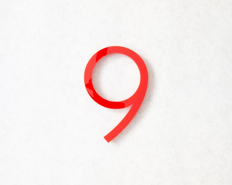 May include: A red number nine made of acrylic. The number is on a white background.